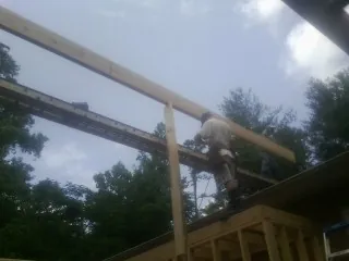 Carpenter setting a ridge beam over a new addition frame — Ice Dam Removal by Roofing Brothers in Rillton