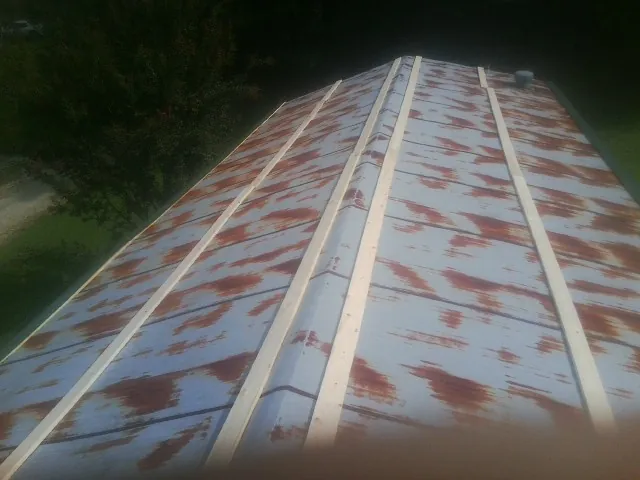Rusted metal roof panels with new wood purlins before replacement — Storm Damage Roof Repair in Rillton by Roofing Brothers