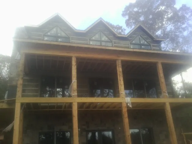 Dormers and porch framing on a large log home under construction — Roof Coating work by our crew in Rillton