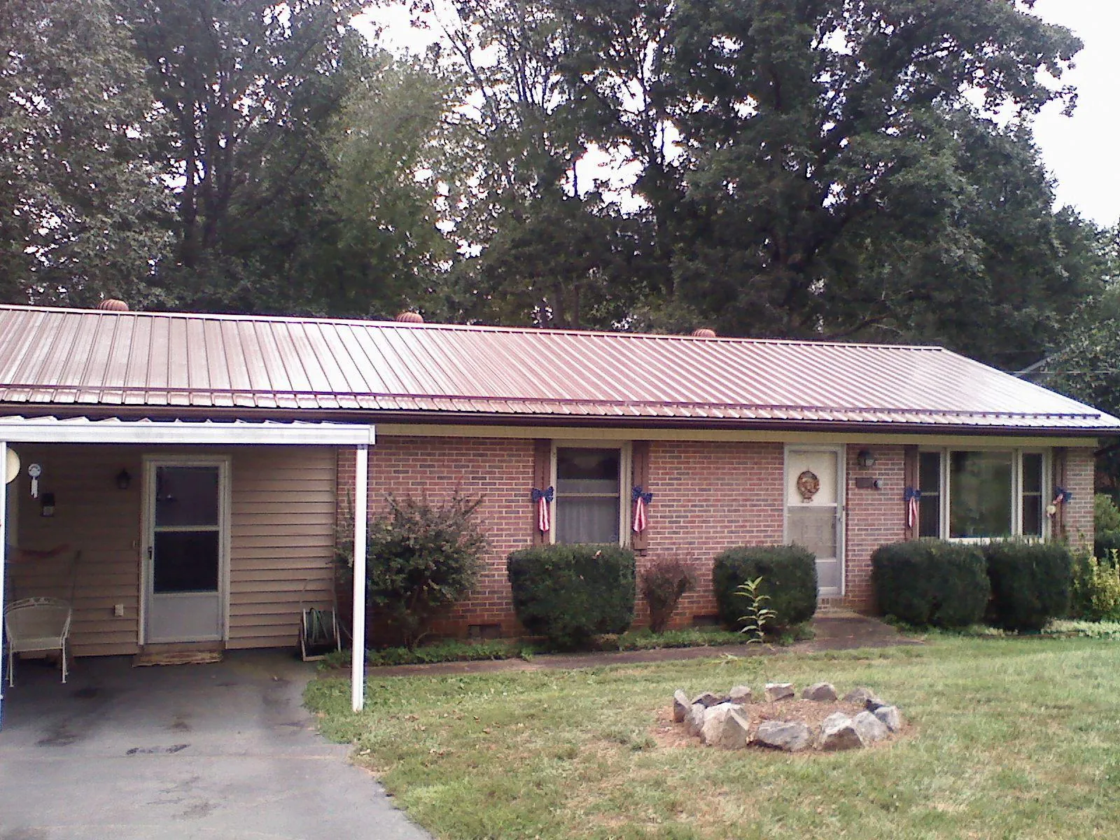 Bronze metal roof and carport on a brick ranch home — Roof Repair work by our crew in Rillton