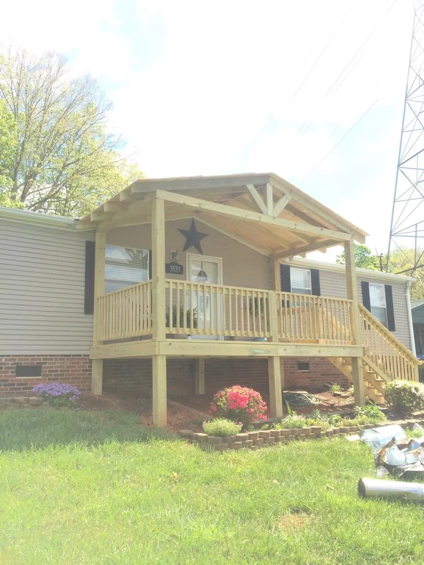 New gabled porch roof and deck railing added to a ranch home in Rillton